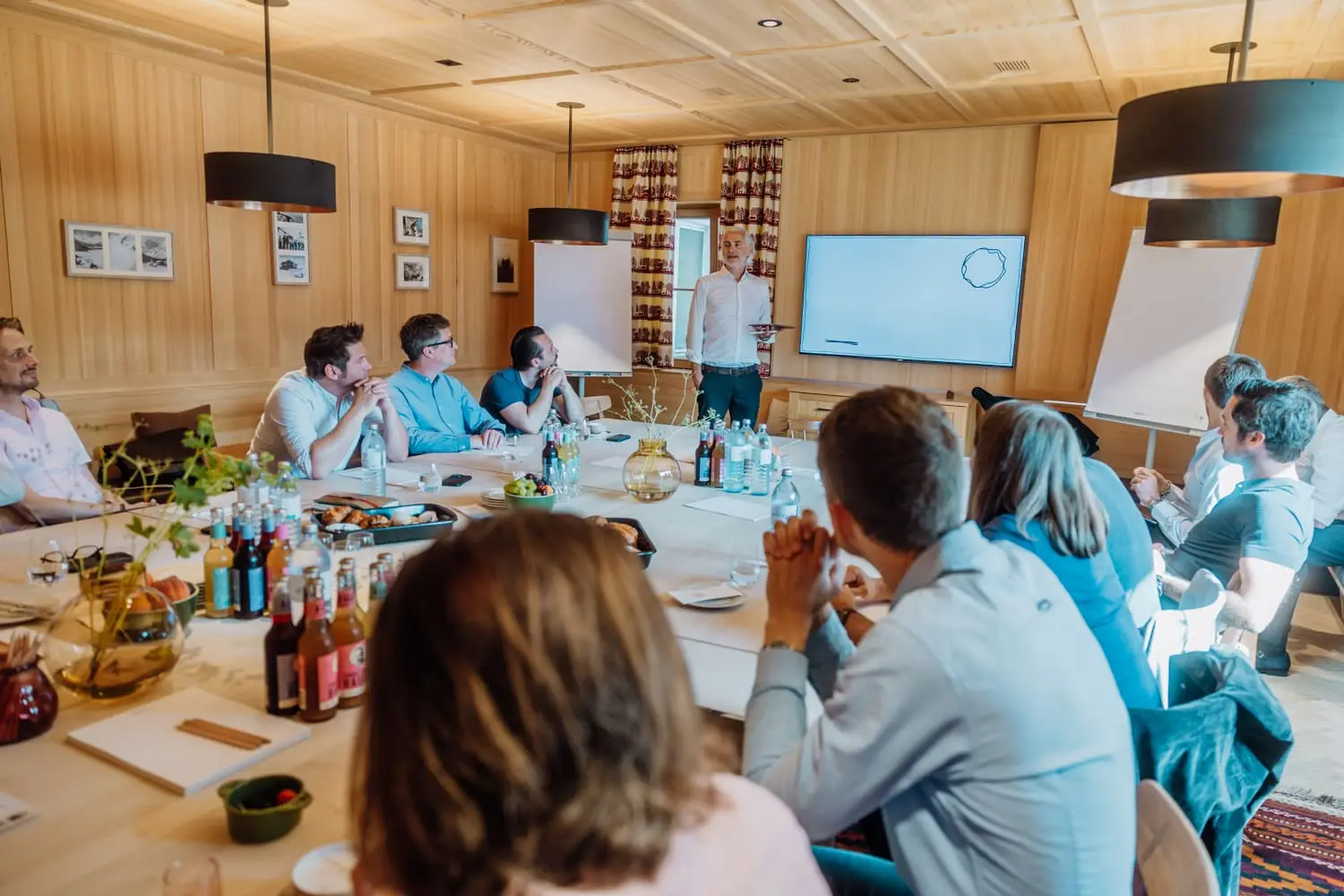 Teilnehmende der Masterclass an einem langen Tisch in Lech